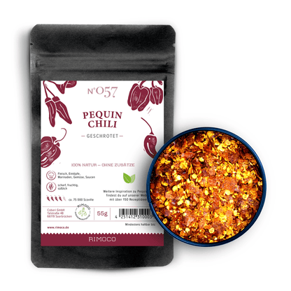 Pequin Chili gemahlene Packung mit einer Schale Chiliflocken daneben auf weißem Hintergrund.