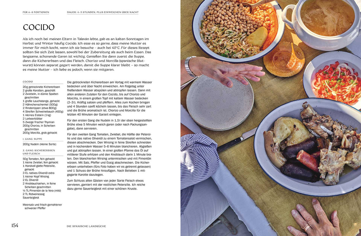 Cocido, Brot, Salat und das Buch Die spanische Landküche von oben auf einen Tisch.
