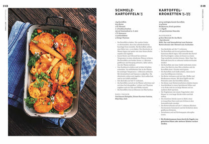 Kartoffeln mit Kräutern und Karotten in einer schwarzen Pfanne, Draufsicht.
