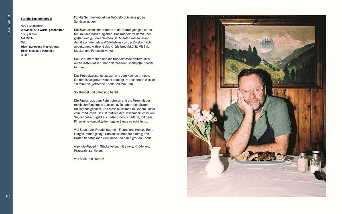 Ein Mann mit Brille sitzt am Tisch mit Essen, Blumen und einem Buch Sepp, was machst du? dahinter.