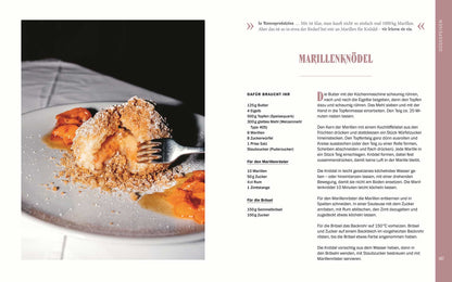 Marillenknödel mit Aprikosensauce und Brösel-Topping auf einem Teller.
