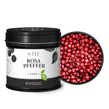 Dose mit Aufschrift Bio Rosa Pfeffer neben einer Schale mit ganzen Rosa Pfefferbeeren.