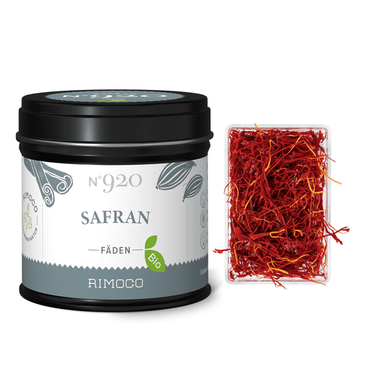 Dosis mit Aufschrift Bio Safran neben offenem Behälter mit Safranfäden von Crocus Sativus.