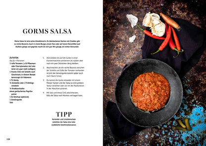 Schüsseln mit Salsa und frischen Zutaten neben dem Saucen-Kochbuch.