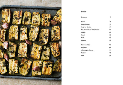 Geröstete Aubergine mit Kräutern und Knoblauch, aufgeschnitten und mit Gewürzen bestreut.