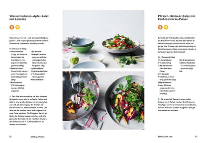 Zwei bunte Sommersalate mit Geschenkset Ottolenghi Simple auf weißem Tisch.