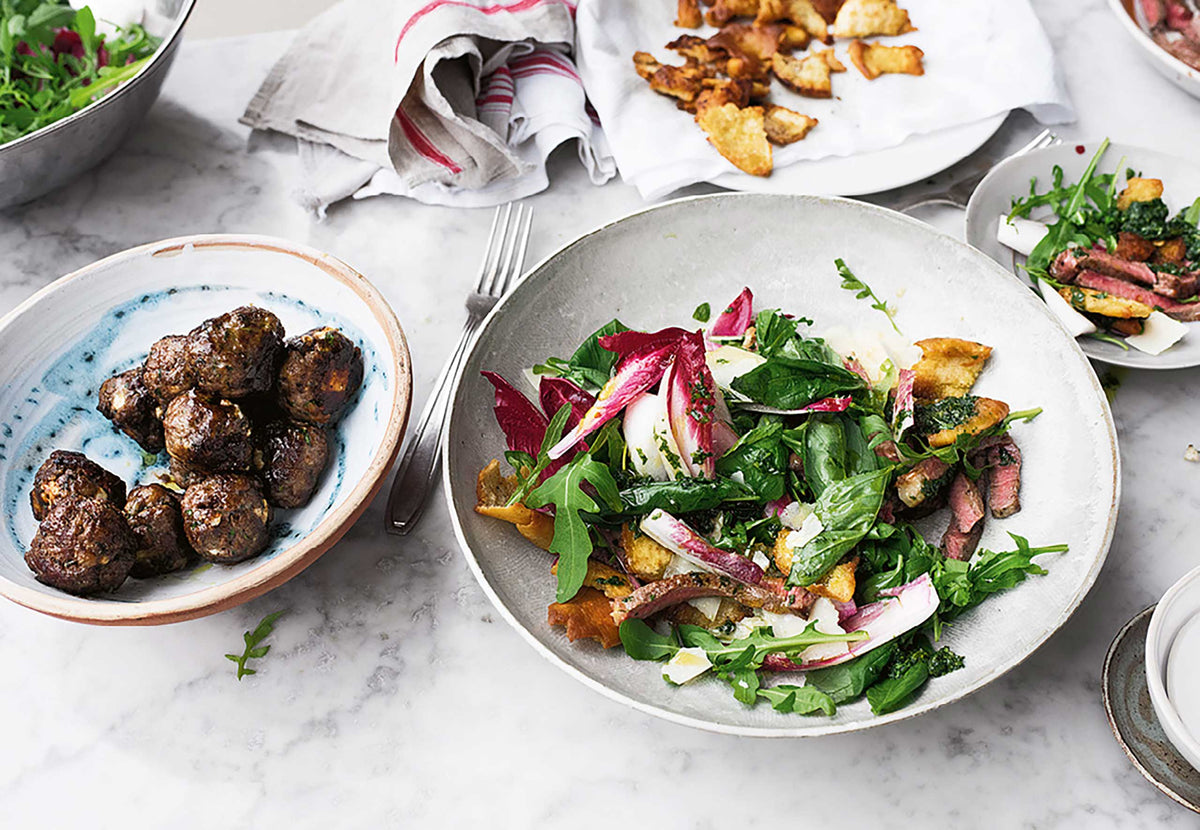 Salat, Steak, orientalische Fleischbällchen und Croutons neben Ottolenghi Simple - Das Kochbuch.