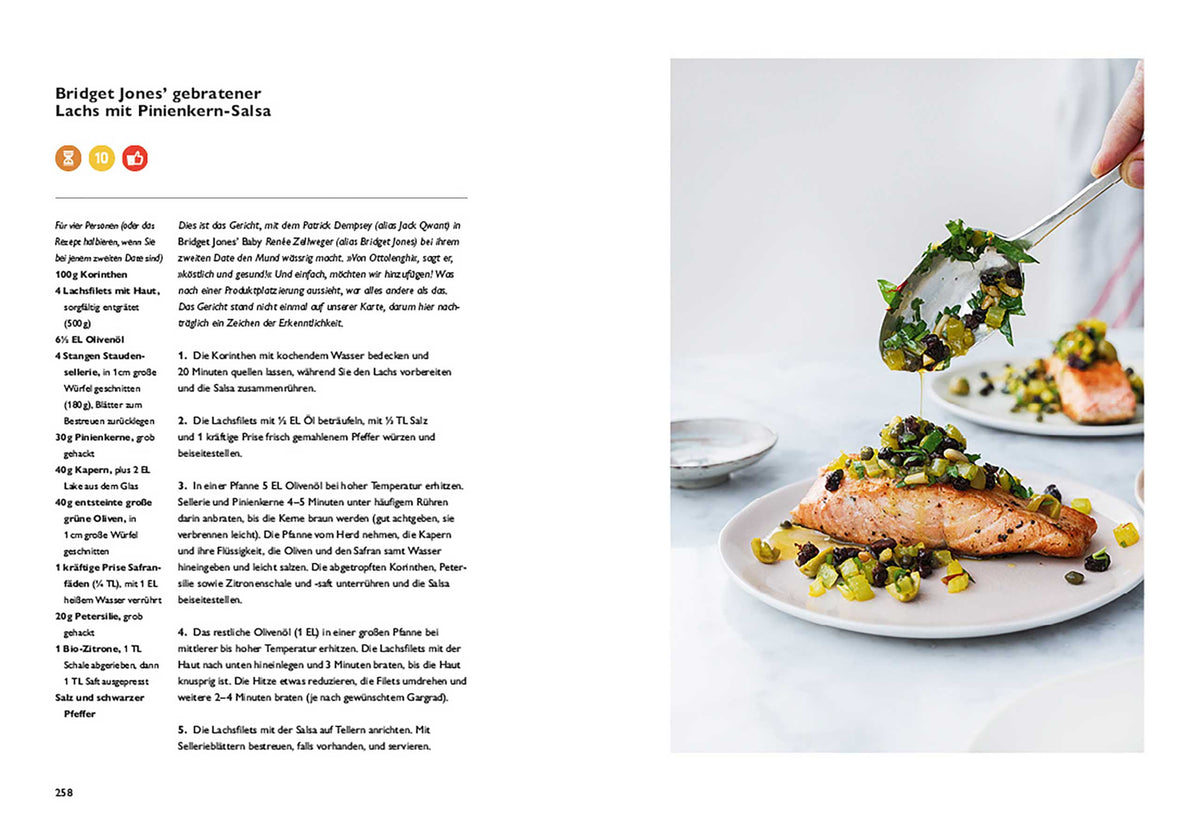 Hand garniert Lachs mit Pinienkern-Salsa, daneben Geschenkset Ottolenghi Simple auf weißem Tisch.