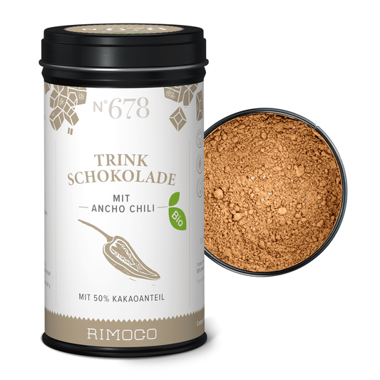 Bio Trinkschokolade mit Ancho Chili steht neben einer geöffneten Dose mit dunklem Kakaopulver.