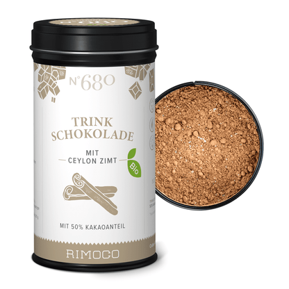 Dose Bio Trinkschokolade mit Ceylon Zimt neben offenem Deckel mit Kakaopulver zu sehen.