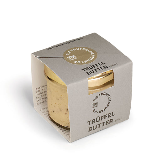 Ein Glas Trüffel Butter mit beiger Verpackung, schwarzer Schrift und rundem Fenster oben.