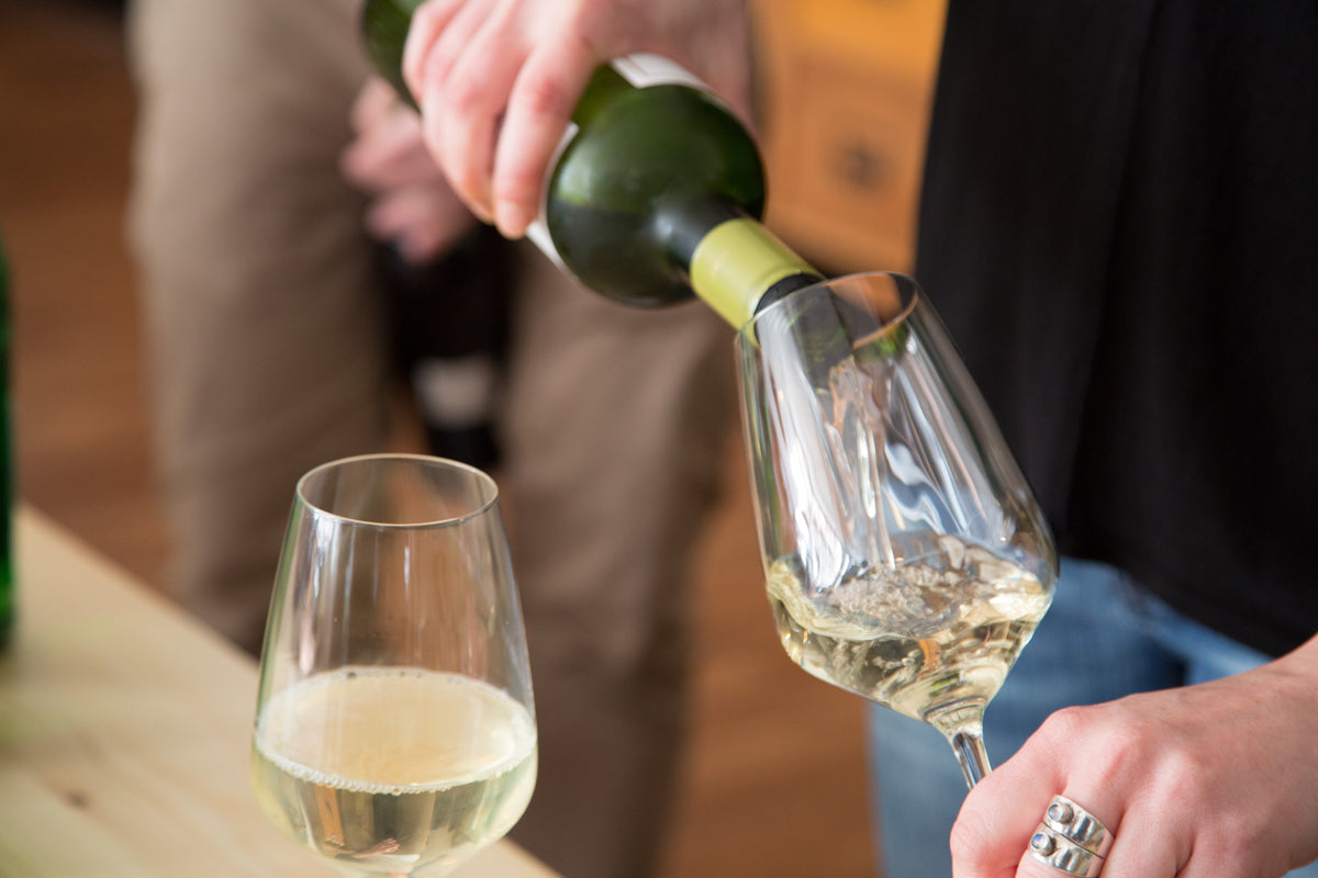 Ein Glas Weißwein steht auf einem Holztisch beim Gewürzseminar Grundkurs in Saarbrücken.