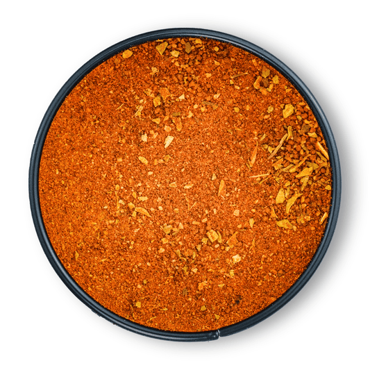 Runde schwarze Schale mit orange-rotem, grobem Bio Wok Gewürz von oben auf weißem Hintergrund.