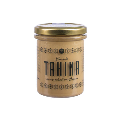 Ottolenghi Profi-Set Glas mit goldenem Deckel, schwarzem Etikett und Granatapfeldicksaft auf Weiß.