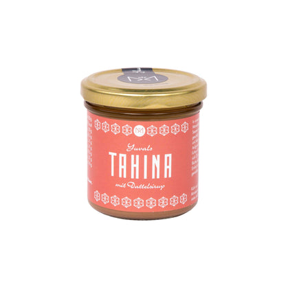 Yuvals Tahina mit Dattelsirup im Glas, mit Sesam und Nüssen, goldenem Deckel und rotem Etikett.