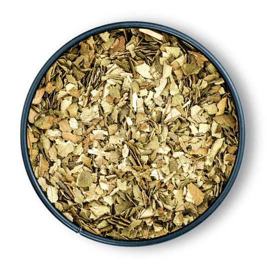 Runde schwarze Schale mit getrockneten Yerba-Mate-Blättern und Bio Zitronenmyrte, von oben gesehen.